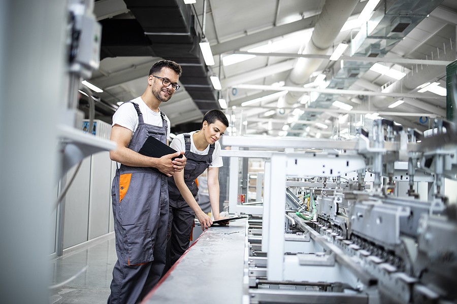 A business is automating production processes with workers observing happily.