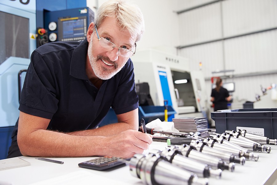 Technician inspecting CNC turned parts used in precision manufacturing applications